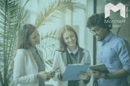 Business team collaborating with digital devices and paperwork in a modern office, representing workplace productivity and IT support services from Moncrieff IT Assist.